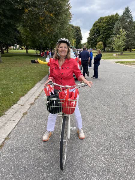 Anna Hopkins on a bicycle decorated with Canadian flags at a neighbourhood celebration