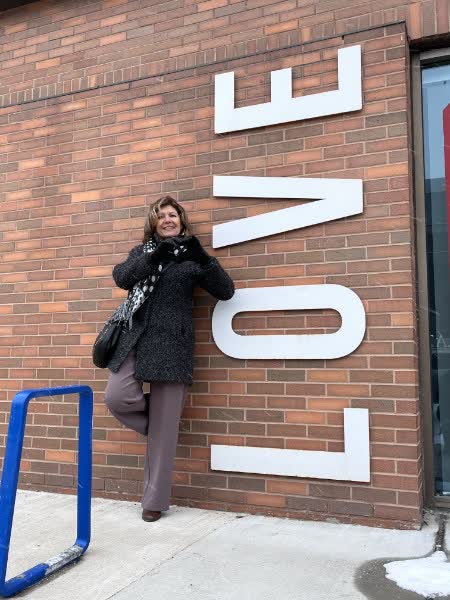 Anna Hopkins beside a large LOVE sign in the city
