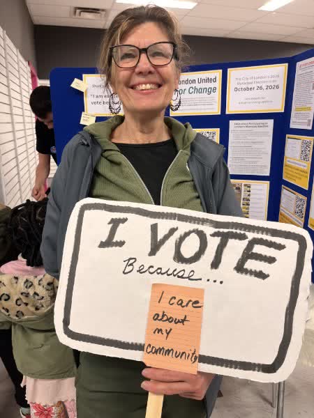 A resident holding a sign reading: I vote because I care about my community